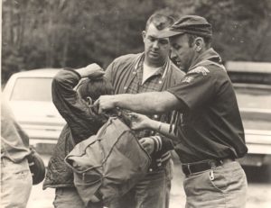 Leader Helps Scout Put on Backpack