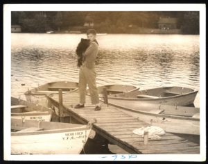 Young Scout Holds Dog on Dock