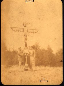 Scout Leaders Stand Around Totem Pole at Camp Russell